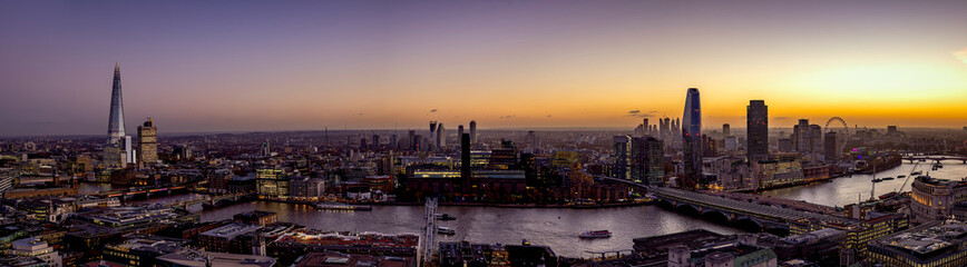 Wide panorama of the skyline of London, UK, during dusk: from London Bridge along the Thames river to Westminster