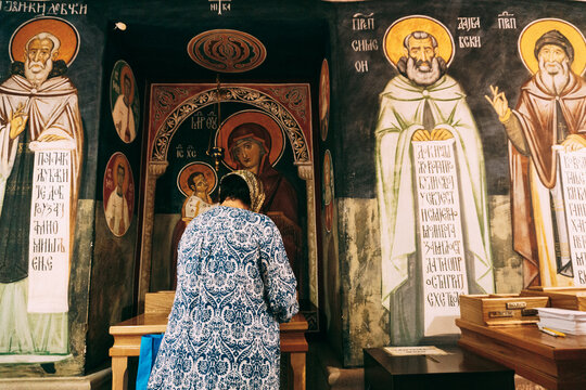 Woman prays in front of the icons in the Ostrog monastery. Montenegro