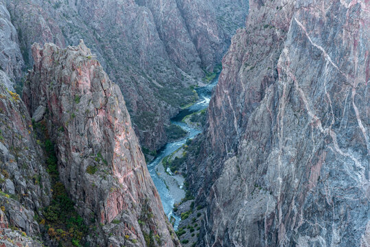 USA, Colorado. Black Canyon of the Gunnison National Park, Gunnison River flows at base of steep metamorphic cliffs. The Painted Wall (right) display lighter igneous bands (intrusions).