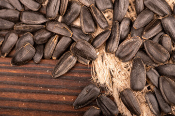 Fried black sunflower seeds scattered on the table, close-up, selective focus.