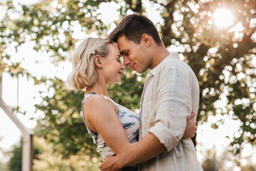 Naklejka premium summer holidays, love and people concept - happy young couple hugging outdoors