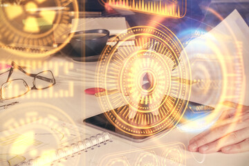 Double exposure of man's hands holding and using a digital device and tech theme hologram drawing. Technology concept.