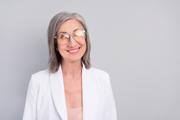 Photo of impressed white hairdo aged lady look empty space wear eyewear blazer isolated on grey color background