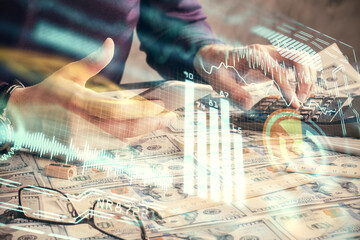 Double exposure of man's hands holding and using a digital device and tech theme hologram drawing. Technology concept.