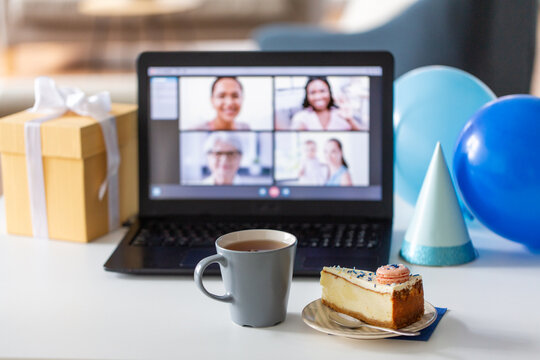 technology and online party concept - piece of birthday cake on plate and laptop computer with video call on screen at home