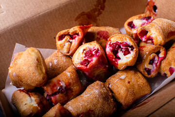 Delicious baked rolls with stuffed fresh cowberry and condensed milk in the box.