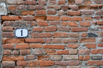 Fototapeta na wymiar old brick wall with house number one