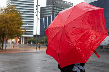 African american man protecting himself from the rain with a red umbrella. Rain concept