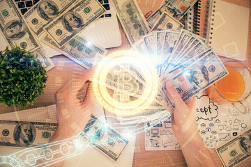 Multi exposure of blockchain theme drawing hologram and USA dollars bills and man hands. Business...