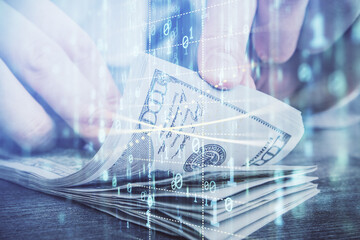 Double exposure of technology drawing hologram and us dollars bills and man hands. Data concept