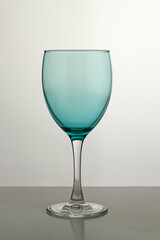 Wine glass made of colored glass on a gray background