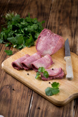 Fresh sausages and ham slices on wooden cutting board, delicious snack, spicy and high quality meat products made of pork and veal, beef.