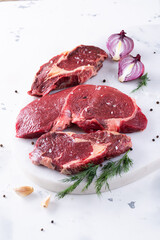 Fresh beef pieces on cutting board, delicious looking ready for steak, with pepper and salt, quality veal meat