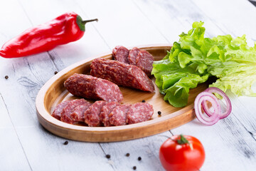Fresh sausages and ham slices on wooden cutting board, delicious snack, spicy and high quality meat...
