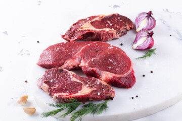 Fresh beef pieces on cutting board, delicious looking ready for steak, with pepper and salt, quality veal meat