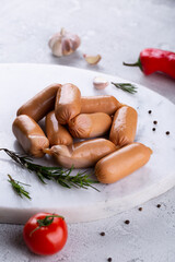 Fresh sausages and ham slices on wooden cutting board, delicious snack, spicy and high quality meat...