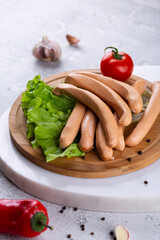 Fresh sausages and ham slices on wooden cutting board, delicious snack, spicy and high quality meat...