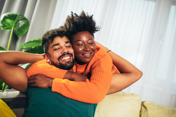 Obraz premium Romantic Young Couple Relaxing Sitting On Sofa Hugging