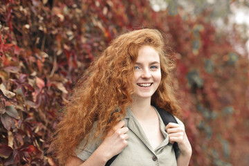 smiling young woman with backpack on her shoulder