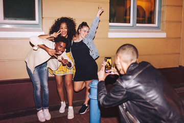 Gen z friends posing for a photo at night