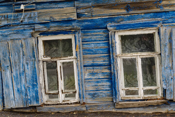 Windows of a dilapidated rickety old wooden house. The picture was taken in Russia, in the city of Orenburg