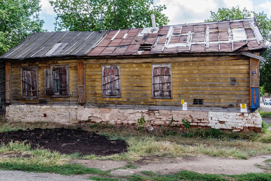 An old dilapidated wooden house with closed shutters and a leaky roof. The picture was taken in Russia, in the city of Orenburg