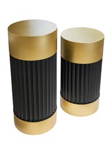 Stylish expensive golden and black cylindrical ribbed bedside tables isolated on white background