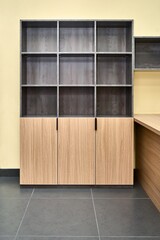 Office storage cabinet for documents with empty shelves made of laminated chipboard with wood and stone texture pattern in spacious office
