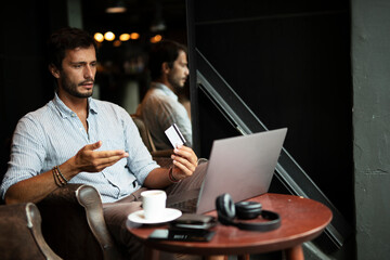 Handsome businessman working on laptop and sitting in cafe. Young student learning online..