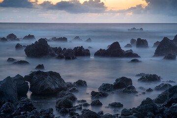 USA, Hawaii, Big Island of Hawaii. Laupahoehoe Point Beach Park, Dawn sky over waves and rough volcanic rock.