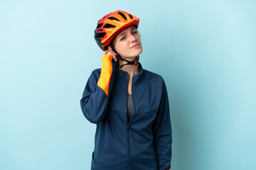 Young cyclist woman isolated on blue background having doubts
