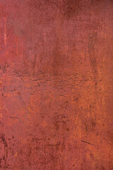 Metallic surface with rusting fencing and crumbling red paint.