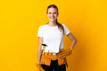 Young electrician woman isolated on yellow background laughing - obrazy, fototapety, plakaty