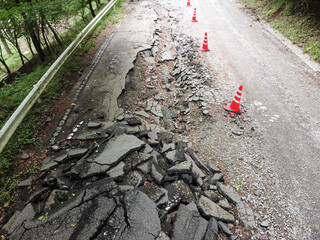 自然災害によって崩れた道路の通行止めの現場