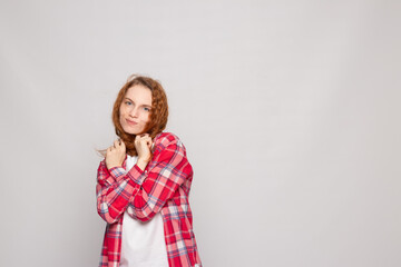 Obraz premium a young girl in a plaid shirt on a light background