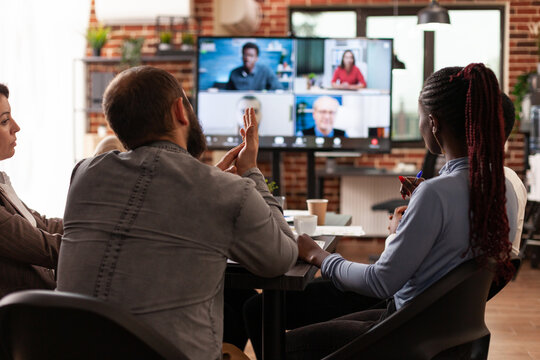 Group Of Businesspeople Working At Company Presentation Discussing Strategy Ideas With Remote Executives Managers During Online Videocall Meeting In Startup Office. Business Call Conference On Monitor