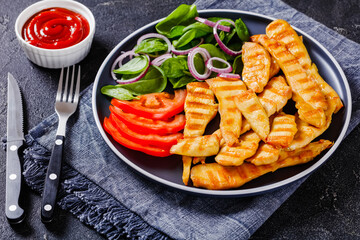 grilled chicken strips on a plate with vegetables