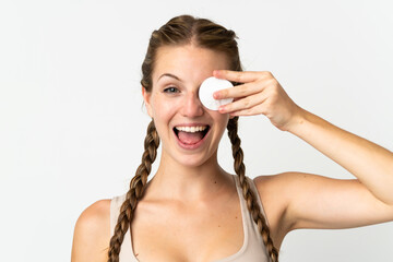 Obraz premium Young caucasian woman isolated on white background with cotton pad for removing makeup from her face and smiling