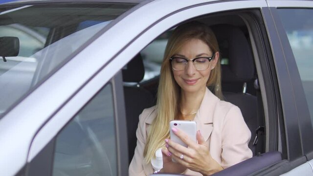 Smiling business lady paying online for petrol or food sitting in car, service
