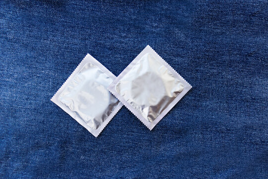 two condoms  on a jeans background. Selective focus. Place for your text.
Prevent HIV disease. Sexually transmitted disease (Mature Content). Contraception. Early adolescent education. diseases. Pregn