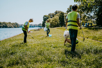 Male and female volunteers cleaning plastics at lakeshore