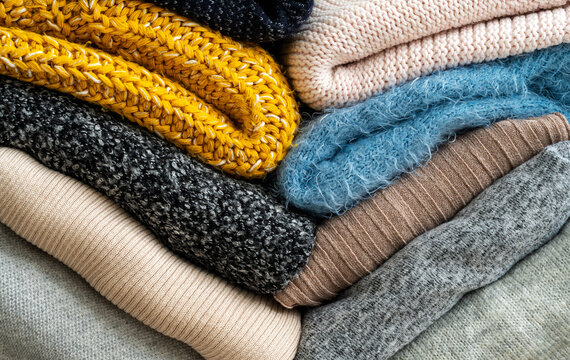 Stack of clothes with different colous and materials.