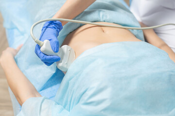 Photography of doctor moving ultrasound probe on pregnant woman stomach during a scheduled appointment