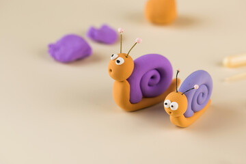  Funny figurines of a snail made of polymer clay. Copy space.