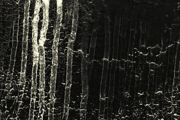 Streaks of dirty liquid on the black surface. Black grunge background