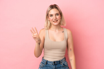 Young caucasian woman isolated on pink background happy and counting three with fingers