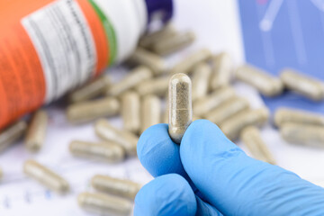 Supplement capsule in scientist hand. Dietary supplement in transparent pill.