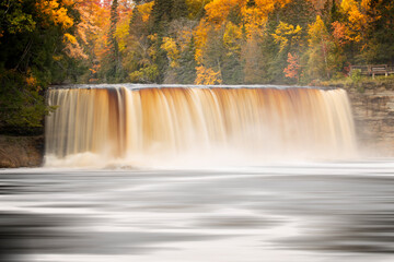 Low angle view of Tahquamenon Falls and fall foliage along Tahquamenon River, Upper Peninsula of Michigan.