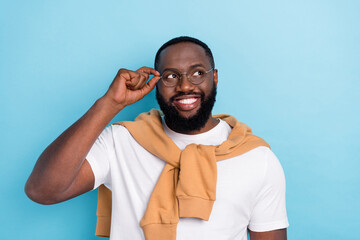 Photo of smart guy look empty space wear spectacles white t-shirt jumper front-tie isolated blue...