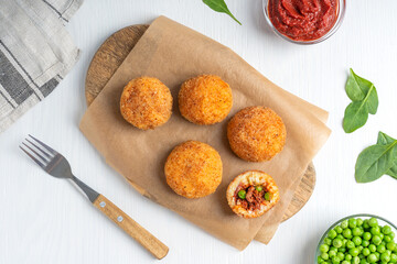 Top view of Arancini Italian rice balls deep fired and stuffed with minced beef meat in tomato...